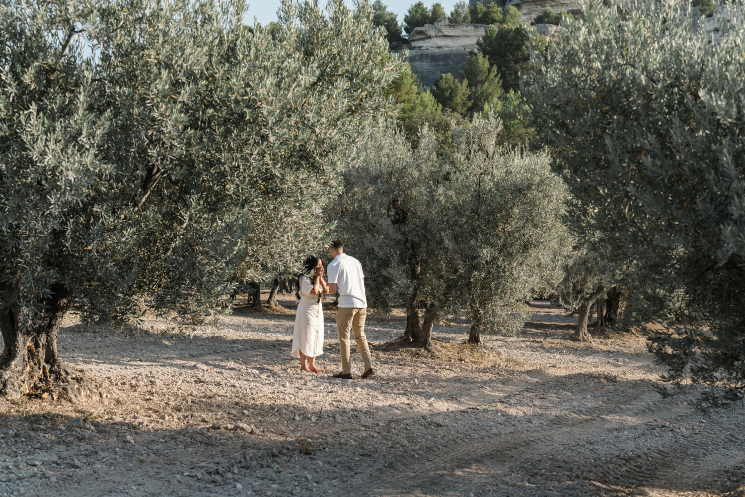 woman is surprised by engagement in olive grove