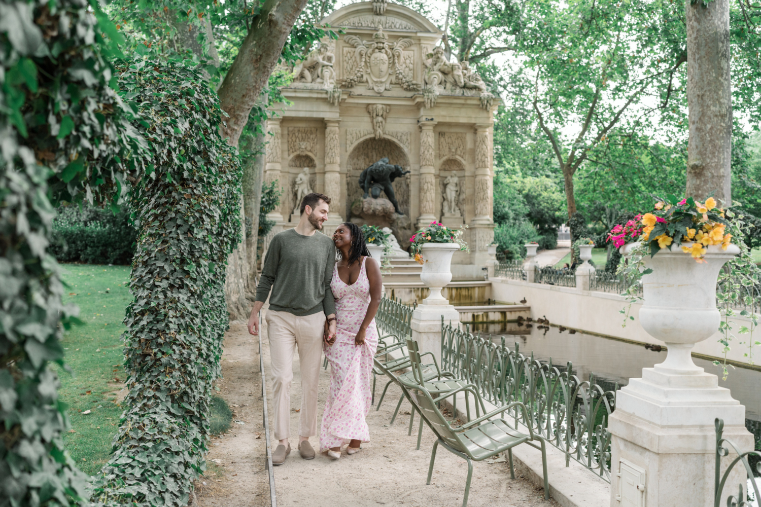 couple in love walk near medicis fountain in luxembourg gardens paris