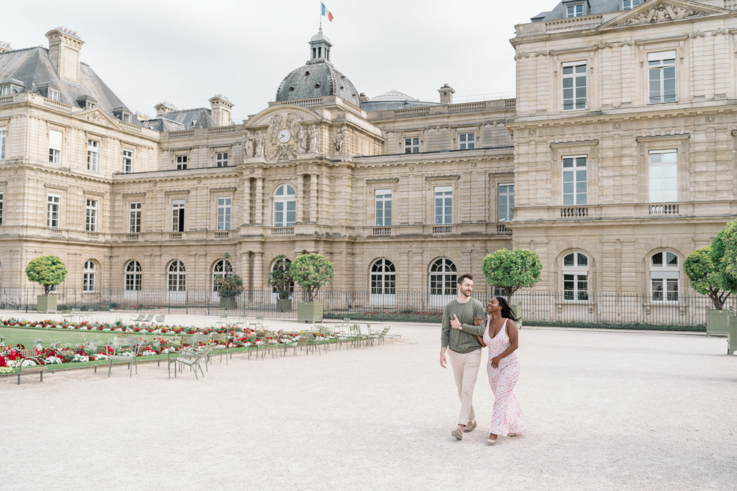 newly engaged couple walk and laugh in luxembourg gardens paris