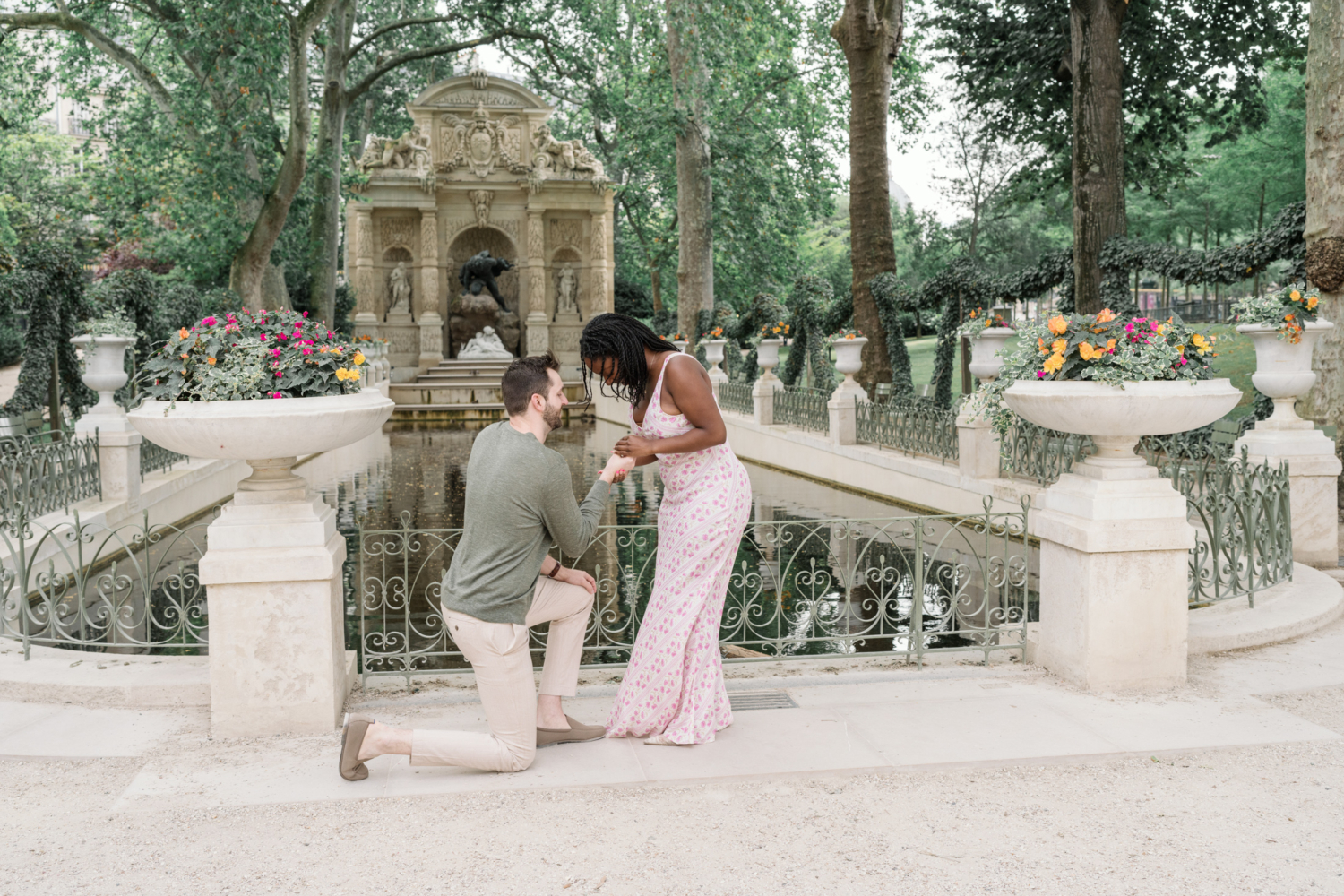 man presents engagement ring to woman in luxembourg gardens paris