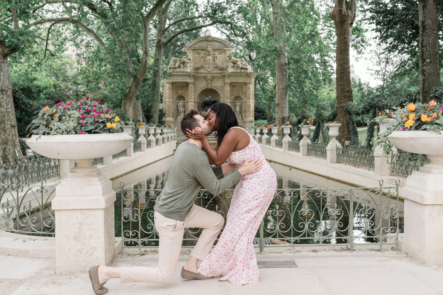 woman kisses man after surprise proposal in luxembourg gardens paris