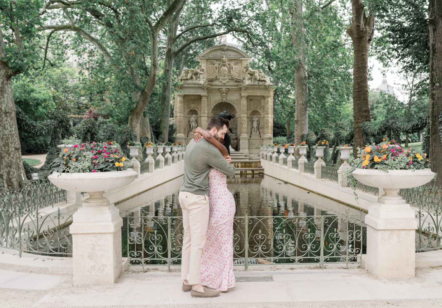 couple embrace after their surprise proposal in luxembourg gardens paris