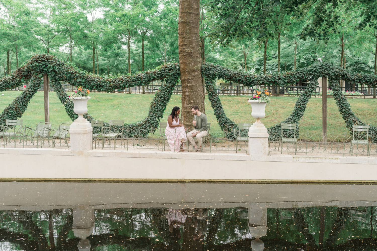 newly engaged couple enjoy champagne in luxembourg gardens paris