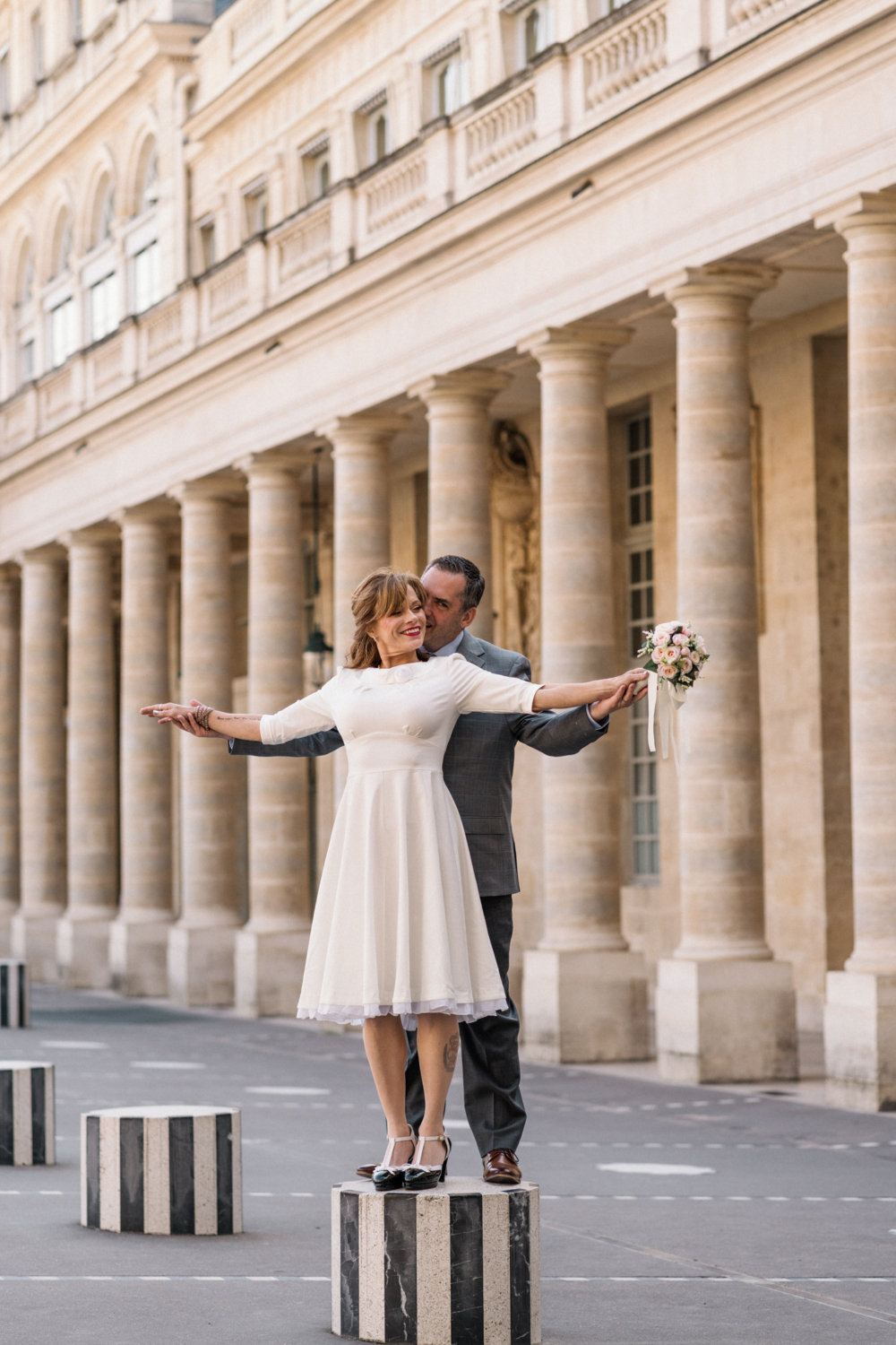 newlyweds embrace at the palais royal paris