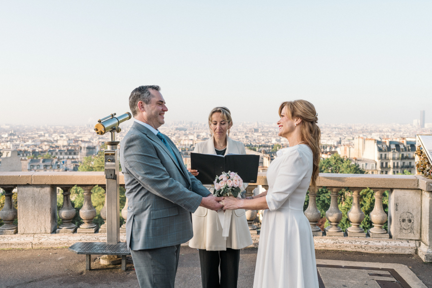 couple hold hands during their wedding ceremony in paris