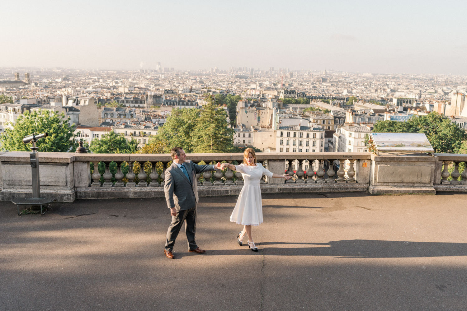 newlyweds dance with a view of paris from montmartre