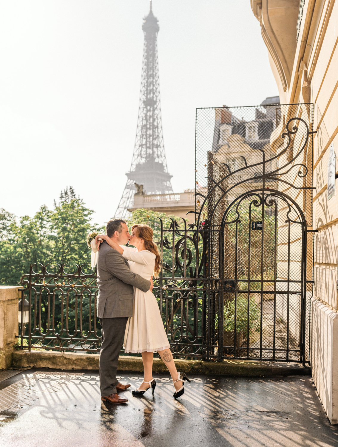 newlyweds kiss with view of the eiffel tower in paris