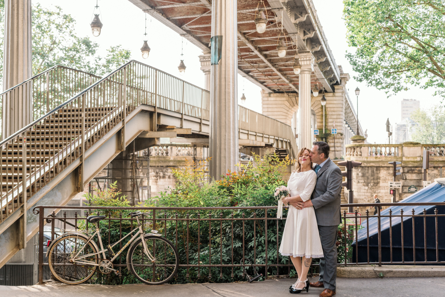 newlyweds embrace under bir hakeim bridge in paris