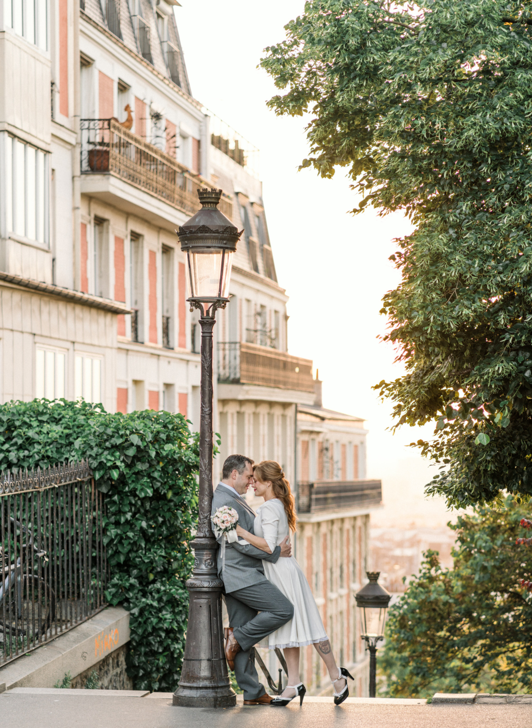 newlyweds pose in front of lamp post in montmartre paris