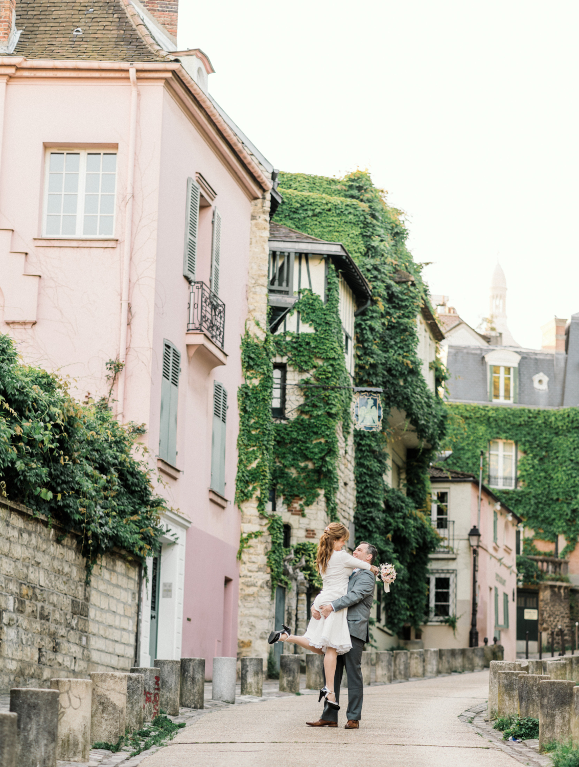 man lifts woman on streets of paris montmartre