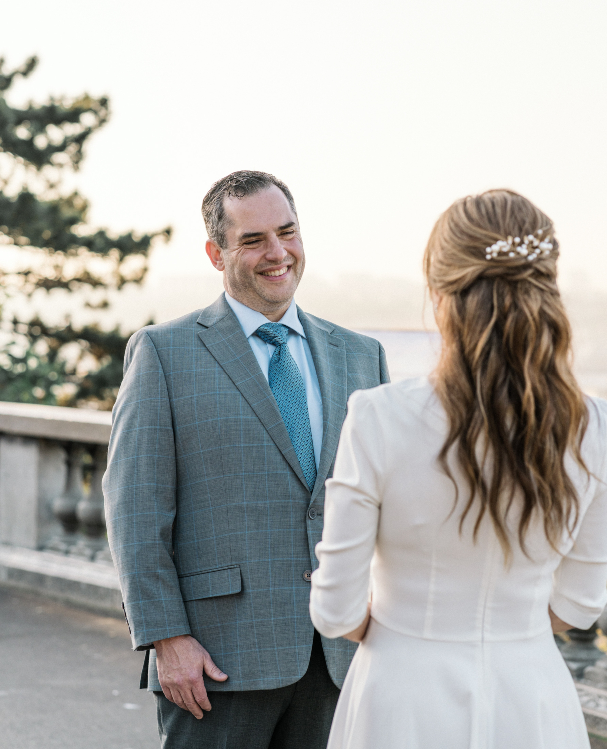 groom smiles at bride during wedding ceremony in paris