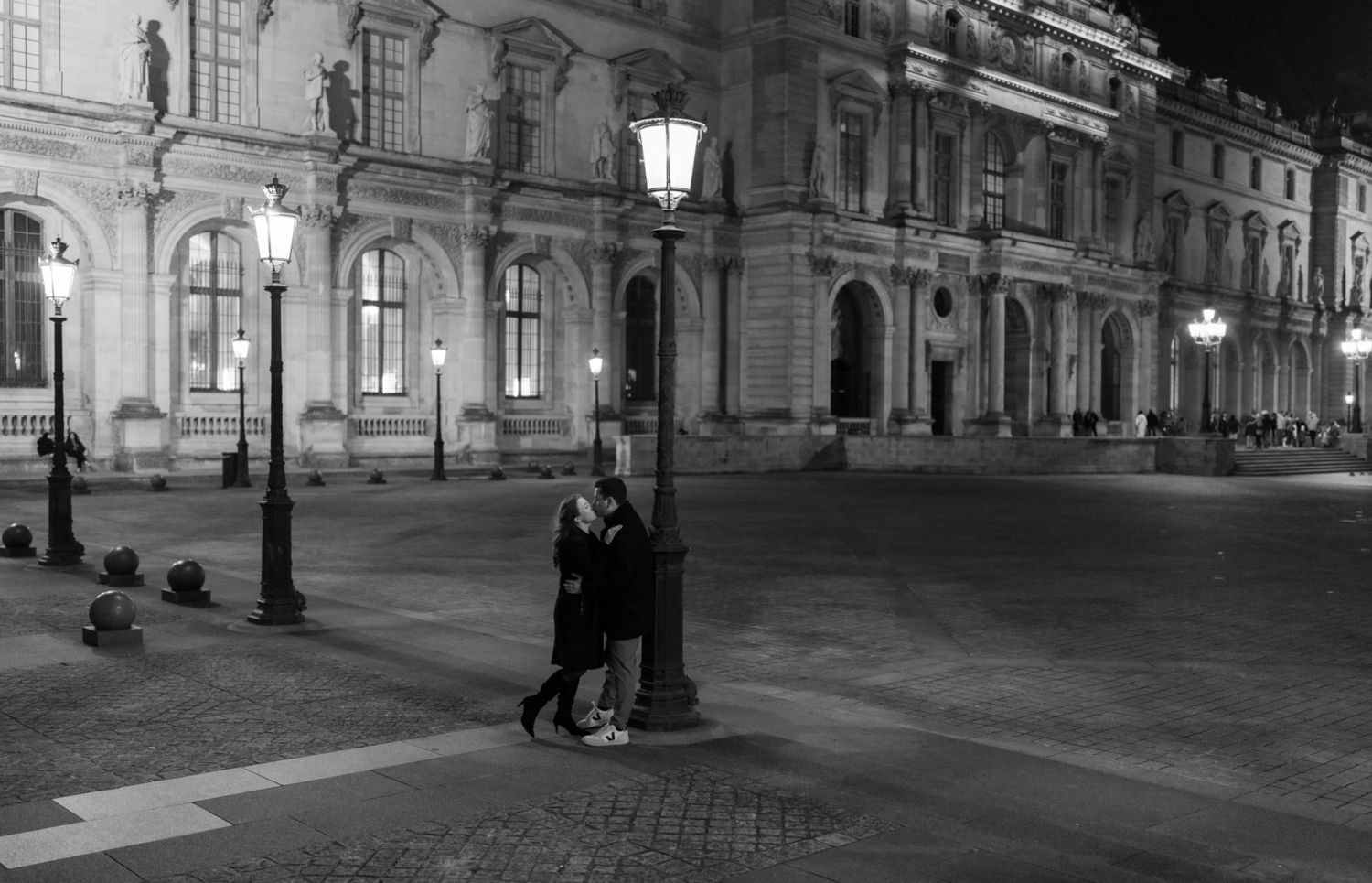 engaged couple embrace and kiss in black and white photoshoot in paris at the louvre