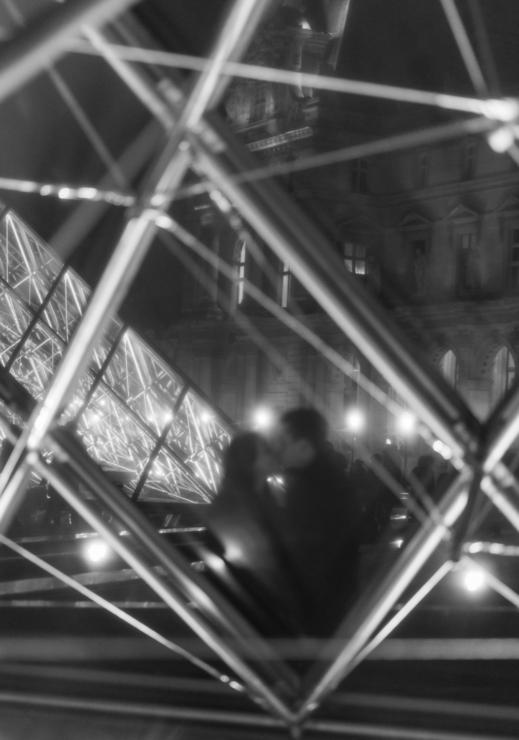 couple kiss at louvre museum in paris in black and white