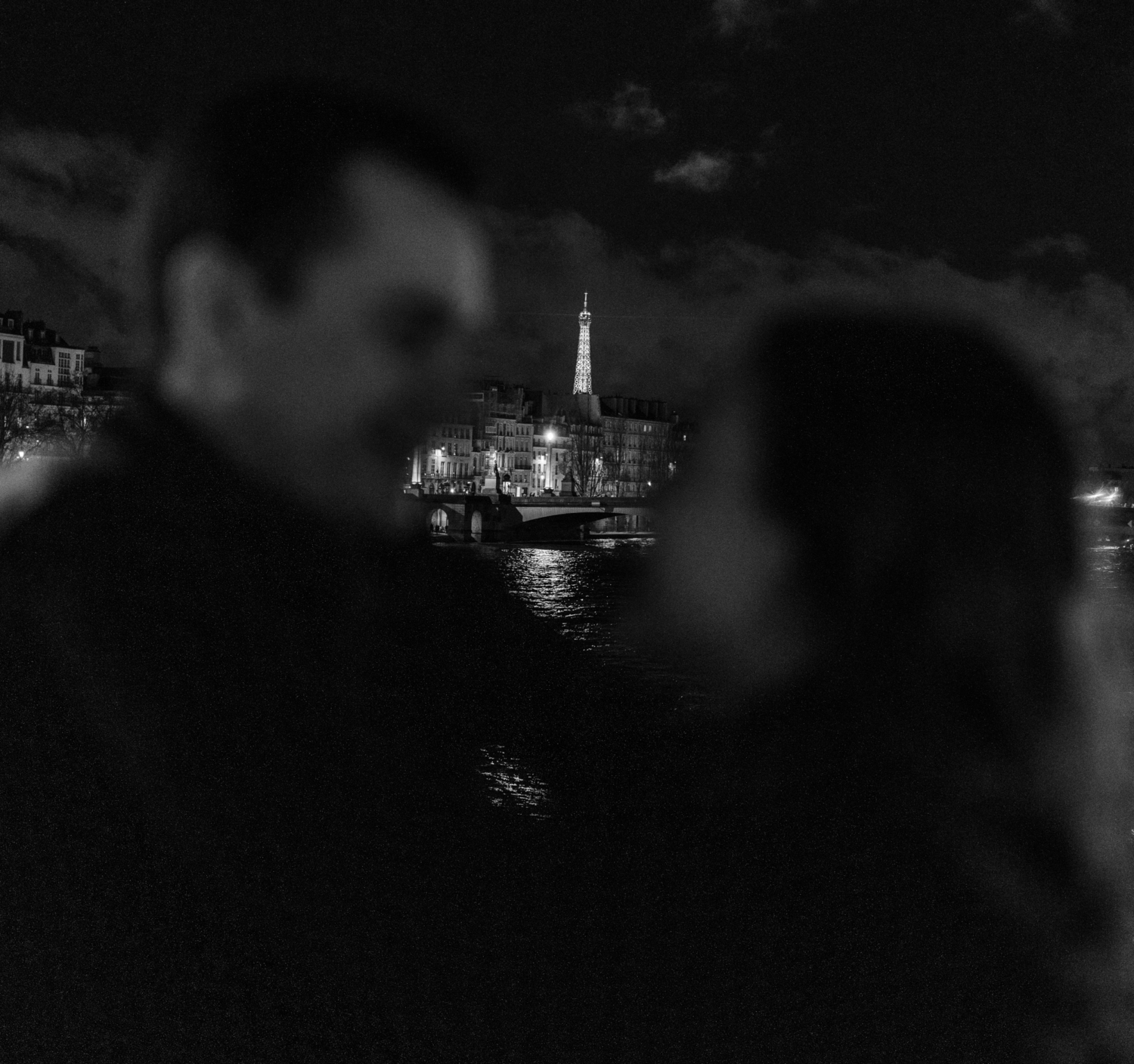 engaged couple pose with night view of eiffel tower in paris