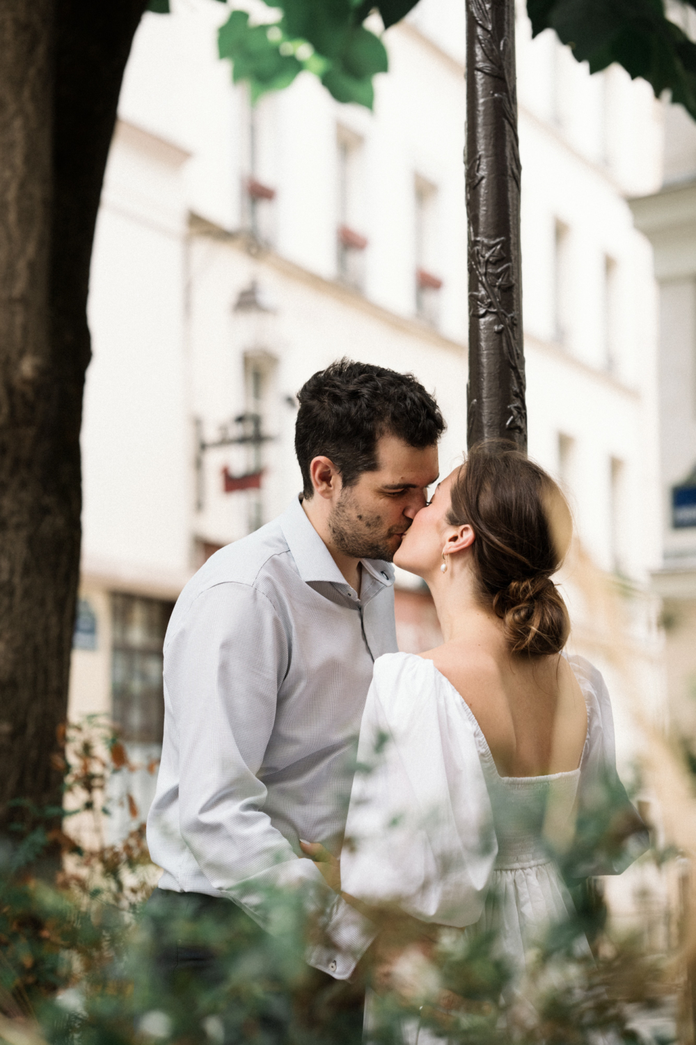 engaged couple kiss under lampost in paris