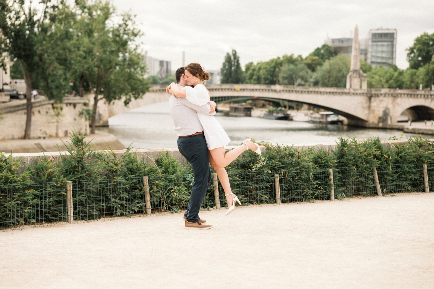 man lifts woman for engagement photoshoot in paris