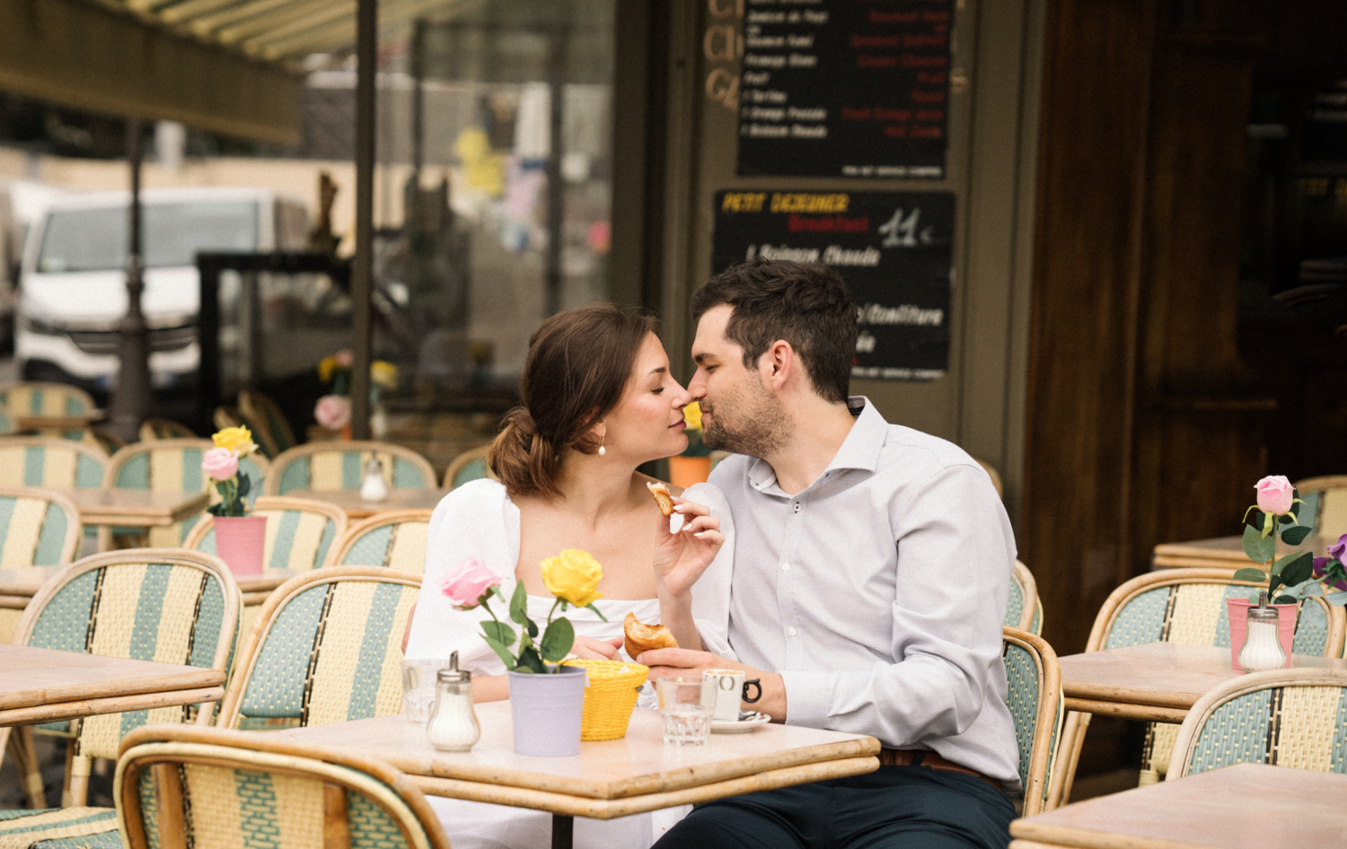 engaged couple get cozy at cafe in paris