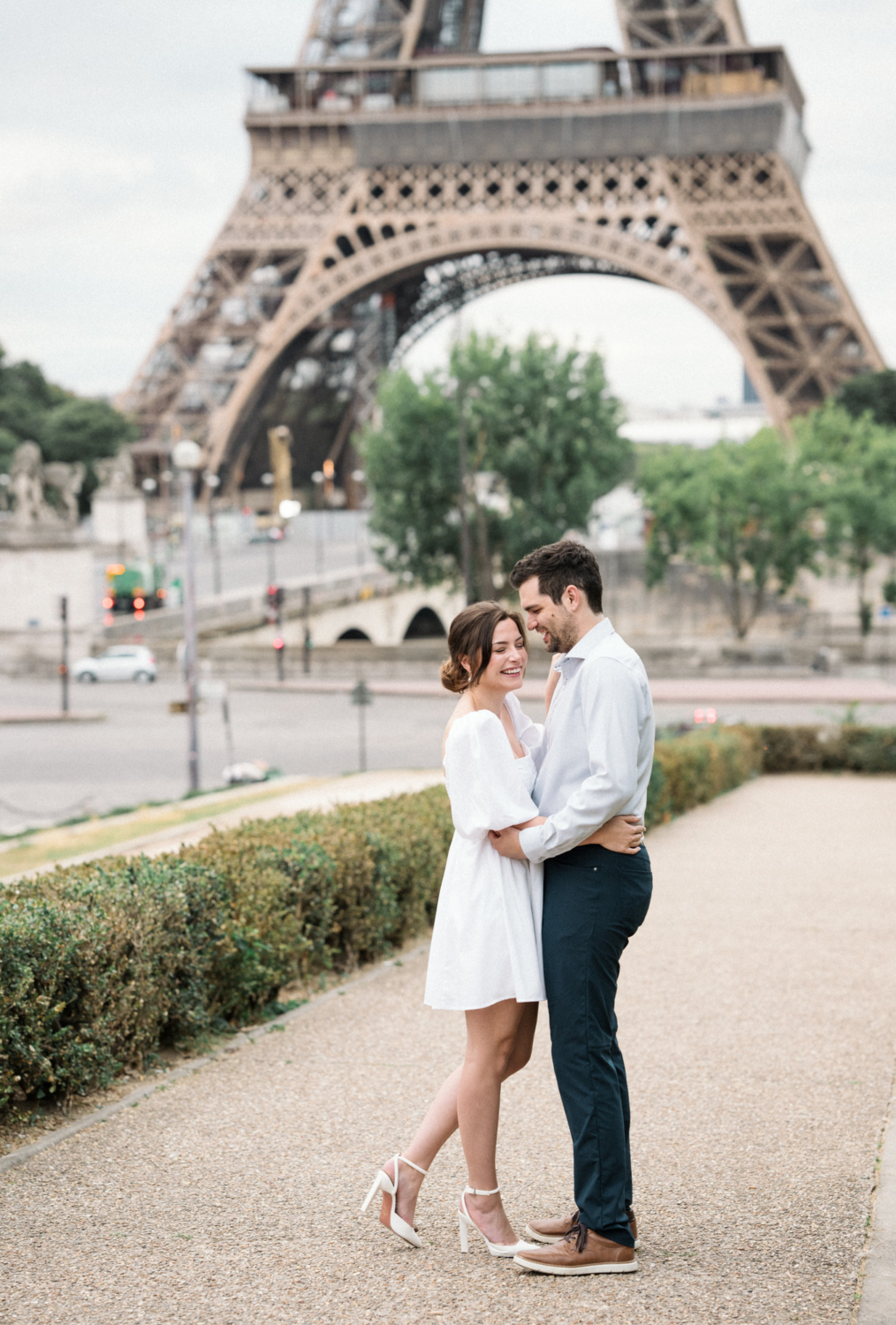 engaged couple share a laugh in paris at the eiffel tower