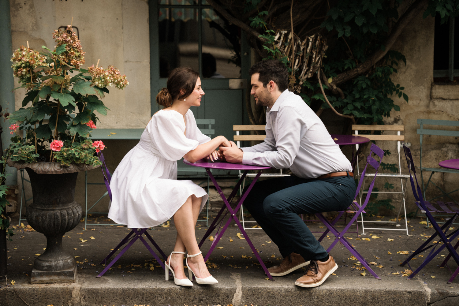 engaged couple hold hands at garden cafe in paris