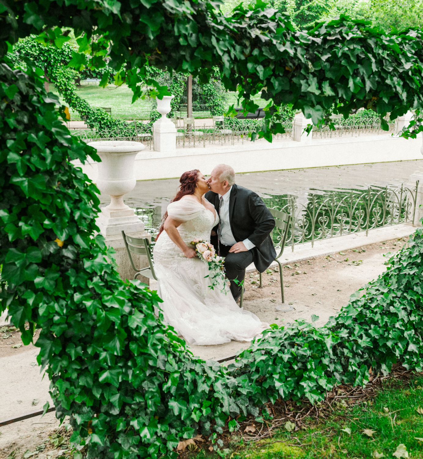 bride and groom kiss among greenery in paris france