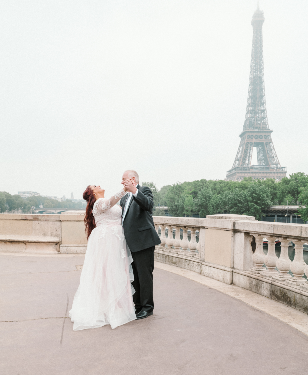 bride and groom laugh and dance at the eiffel tower