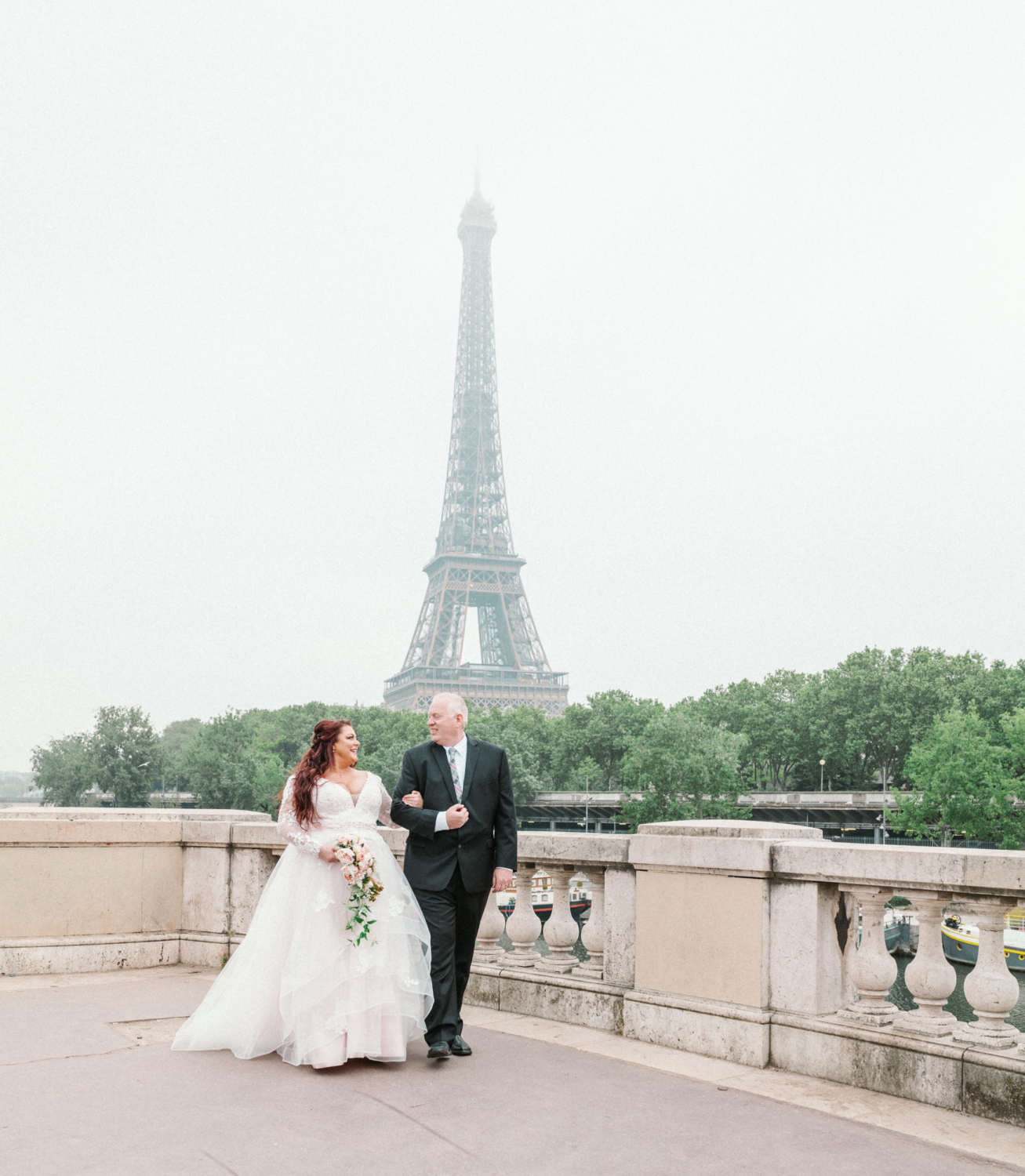 happy bride and groom walk arm in arm at the eiffel tower