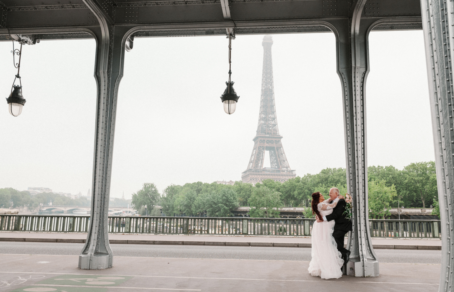 bride and groom embrace on bir hakeim bridge in paris france