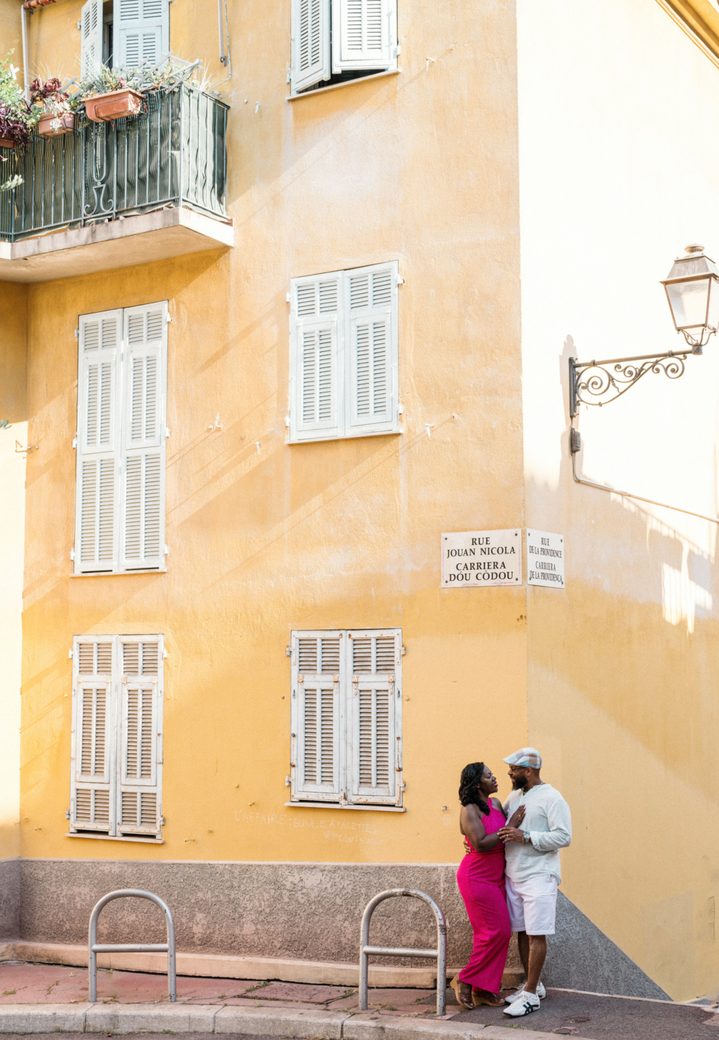couple embrace next to yellow building in nice france