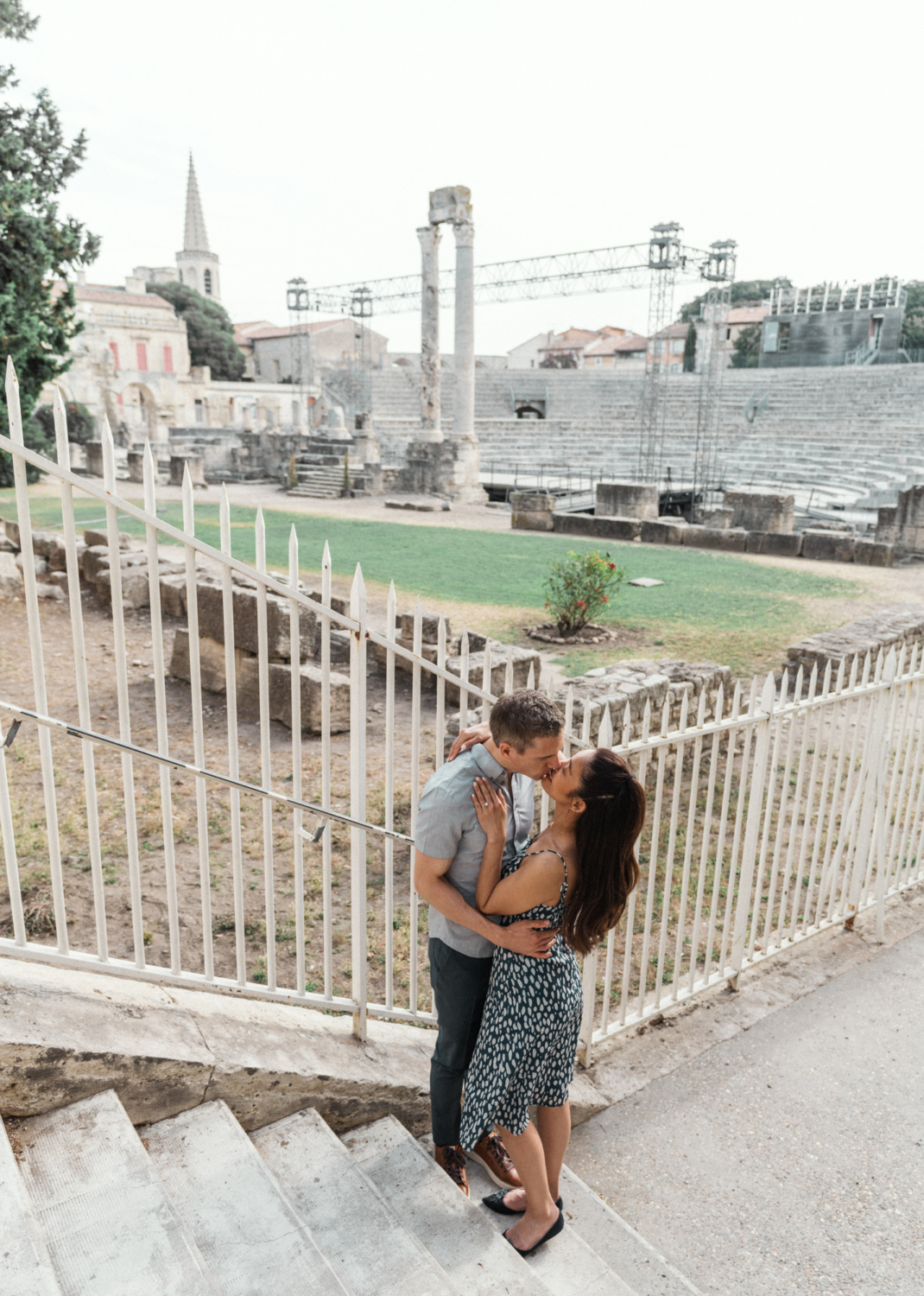 engaged couple kiss with view of roman theater in arles france