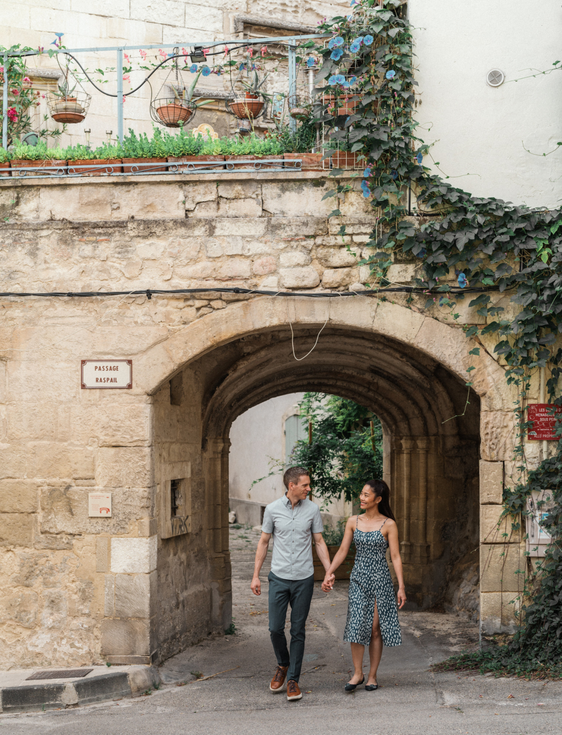 smiling couple walking through medieval archway