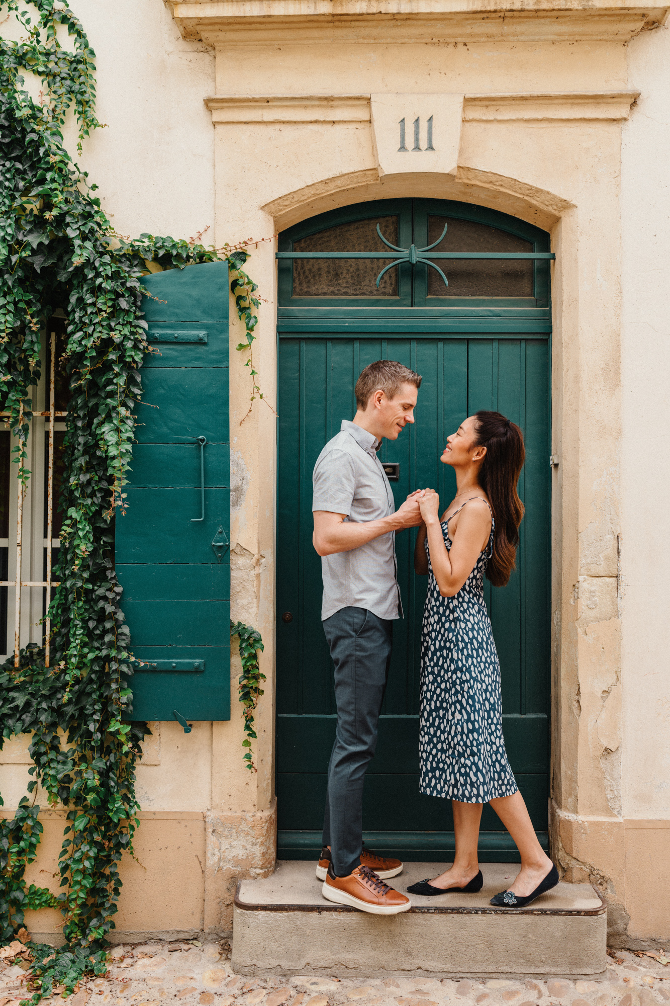 couple hold hands and smile on doorstep