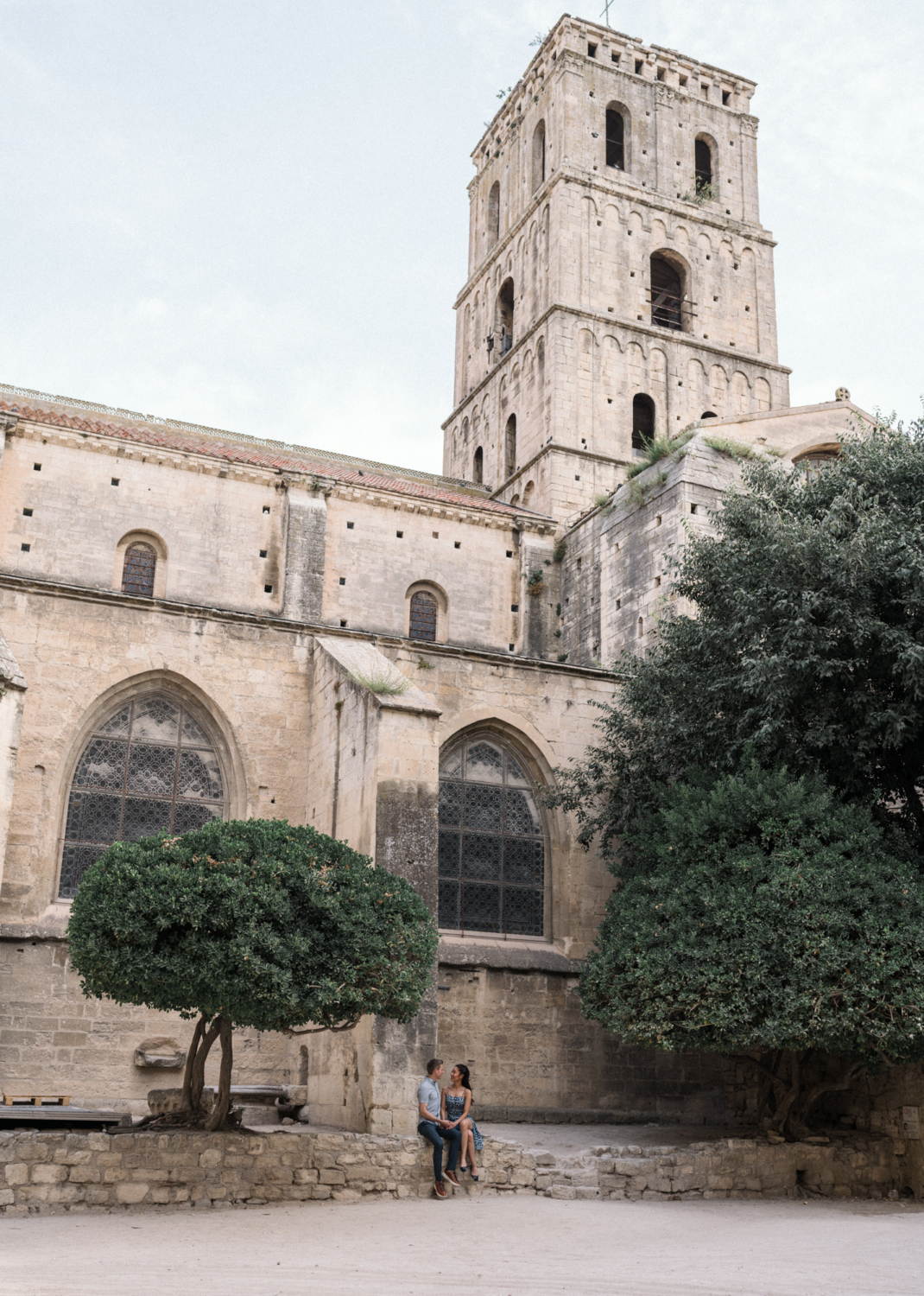 couple sit on ledge beneath old church