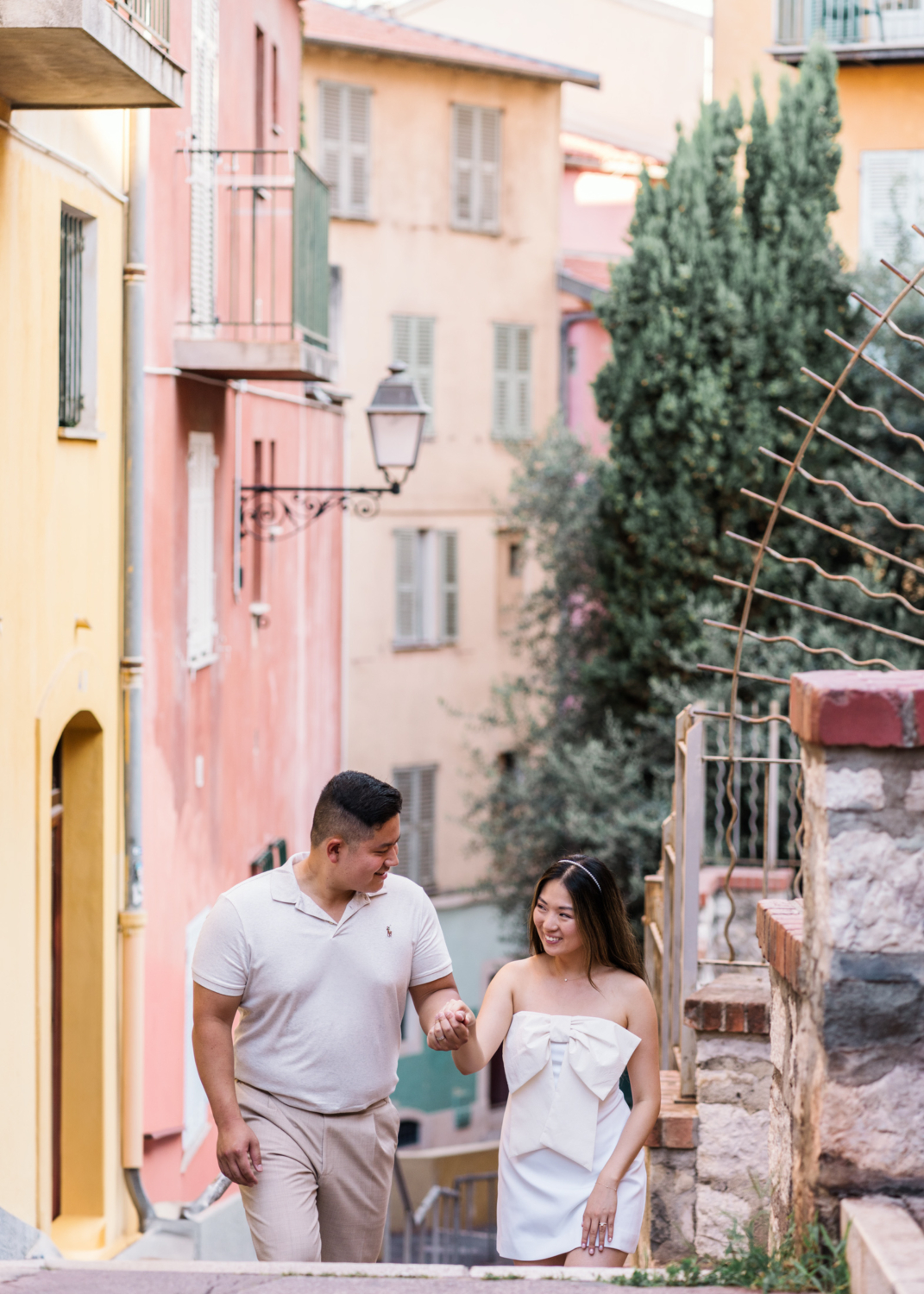 newly married couple walk through the colorful streets of old town nice france