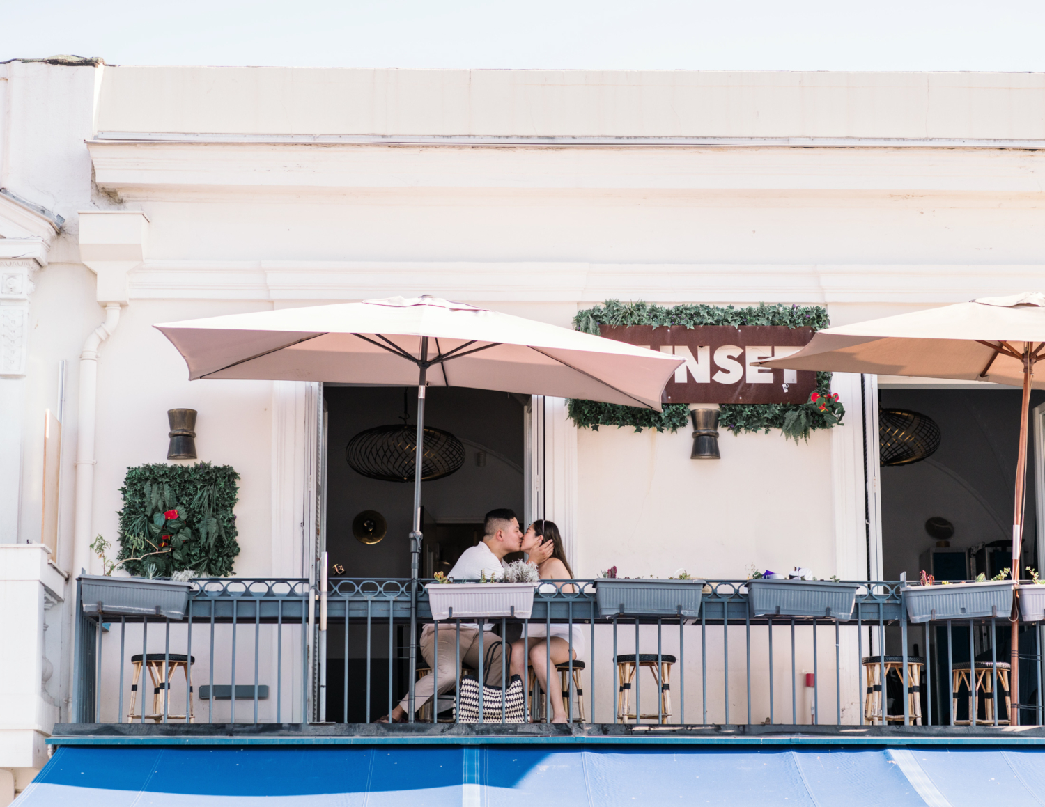 honeymooners kiss on balcony of sunset in nice france