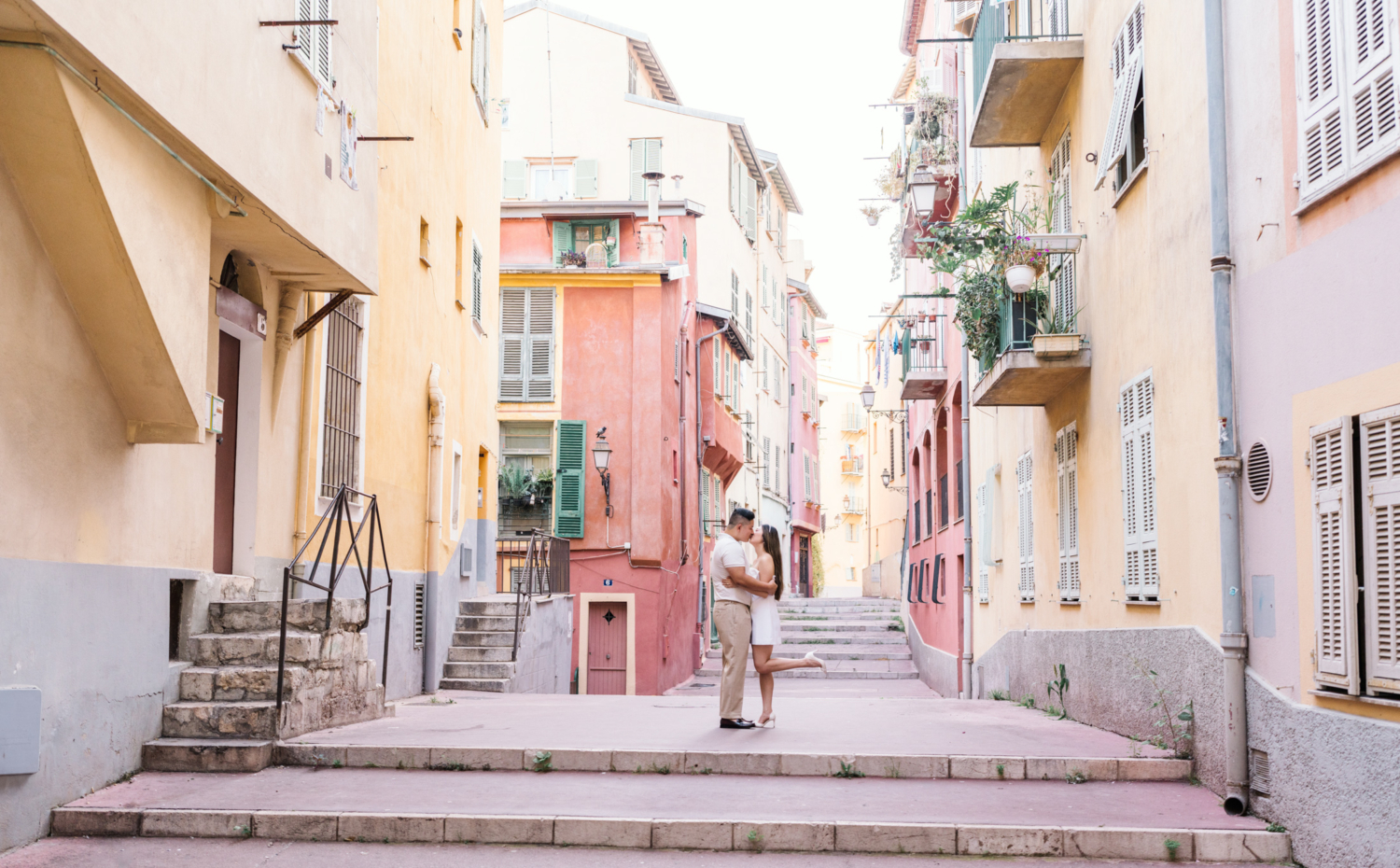 husband and wife kiss in colorful old town nice france