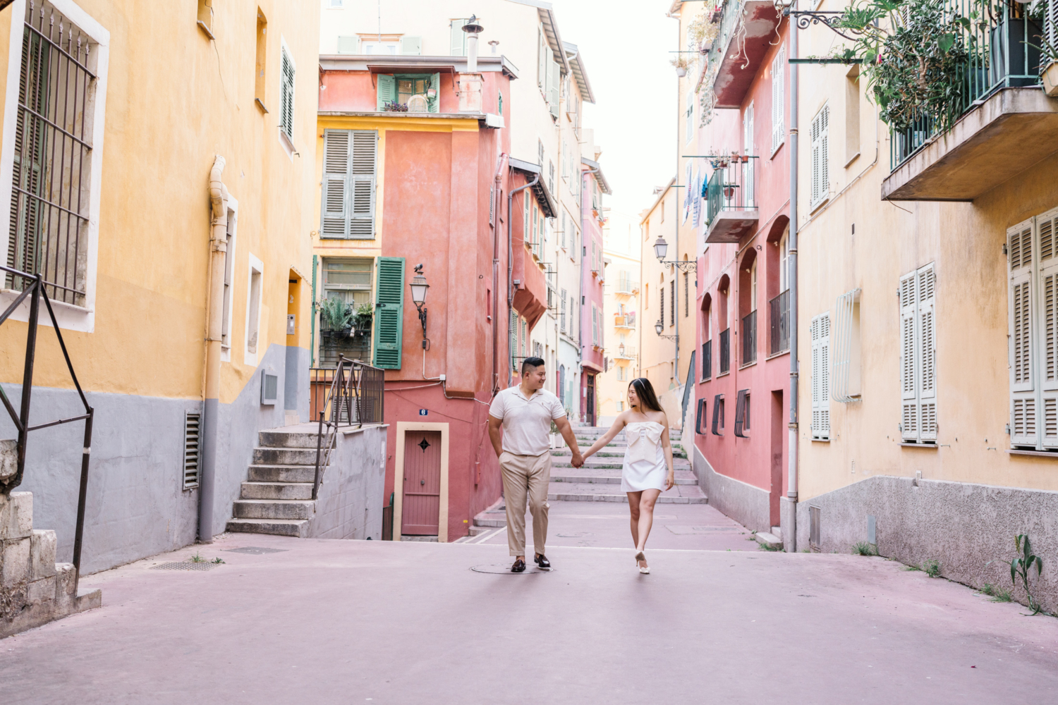 happy couple walk in colorful neighborhood in nice france