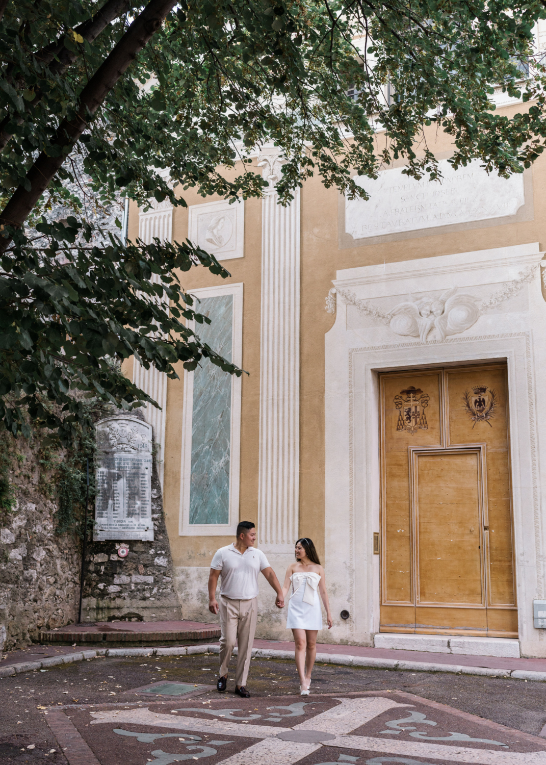 newlyweds hold hands walking near beautiful church in nice france