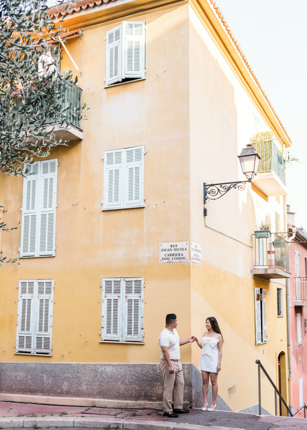 newlywed couple stand next to yellow building in old town nice france