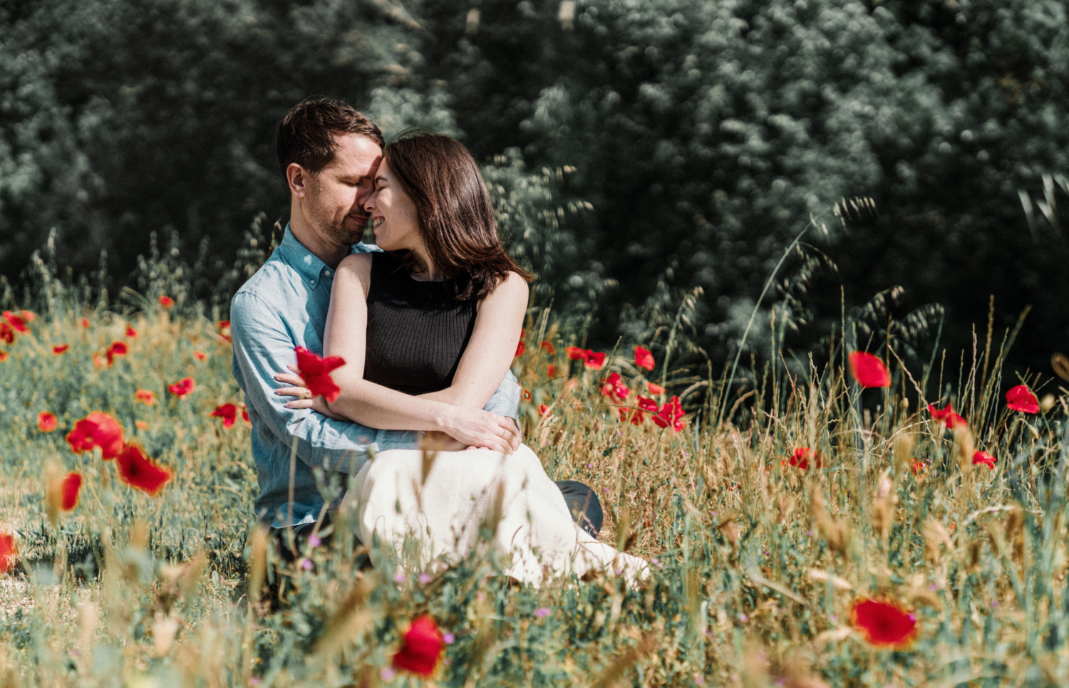 engaged couple embrace in poppy field in arles