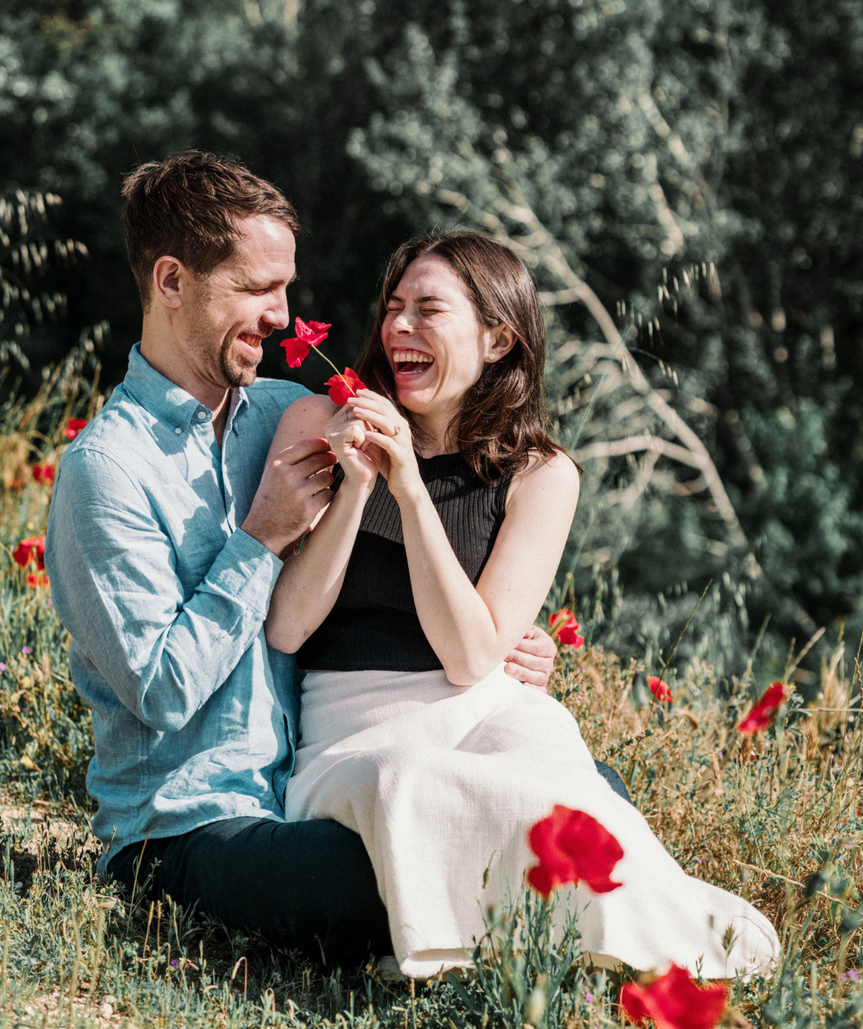 couple hold poppies and laugh
