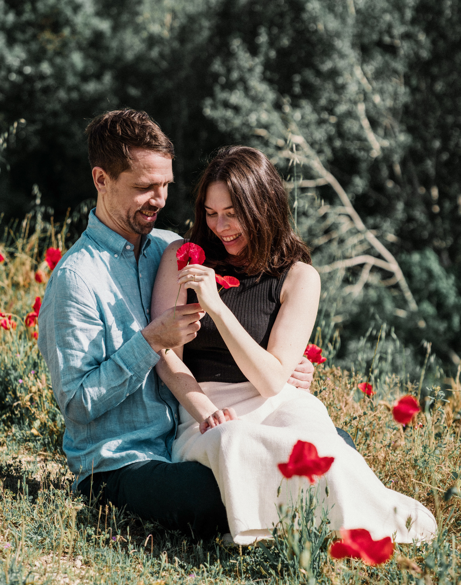 couple hold poppies and smile