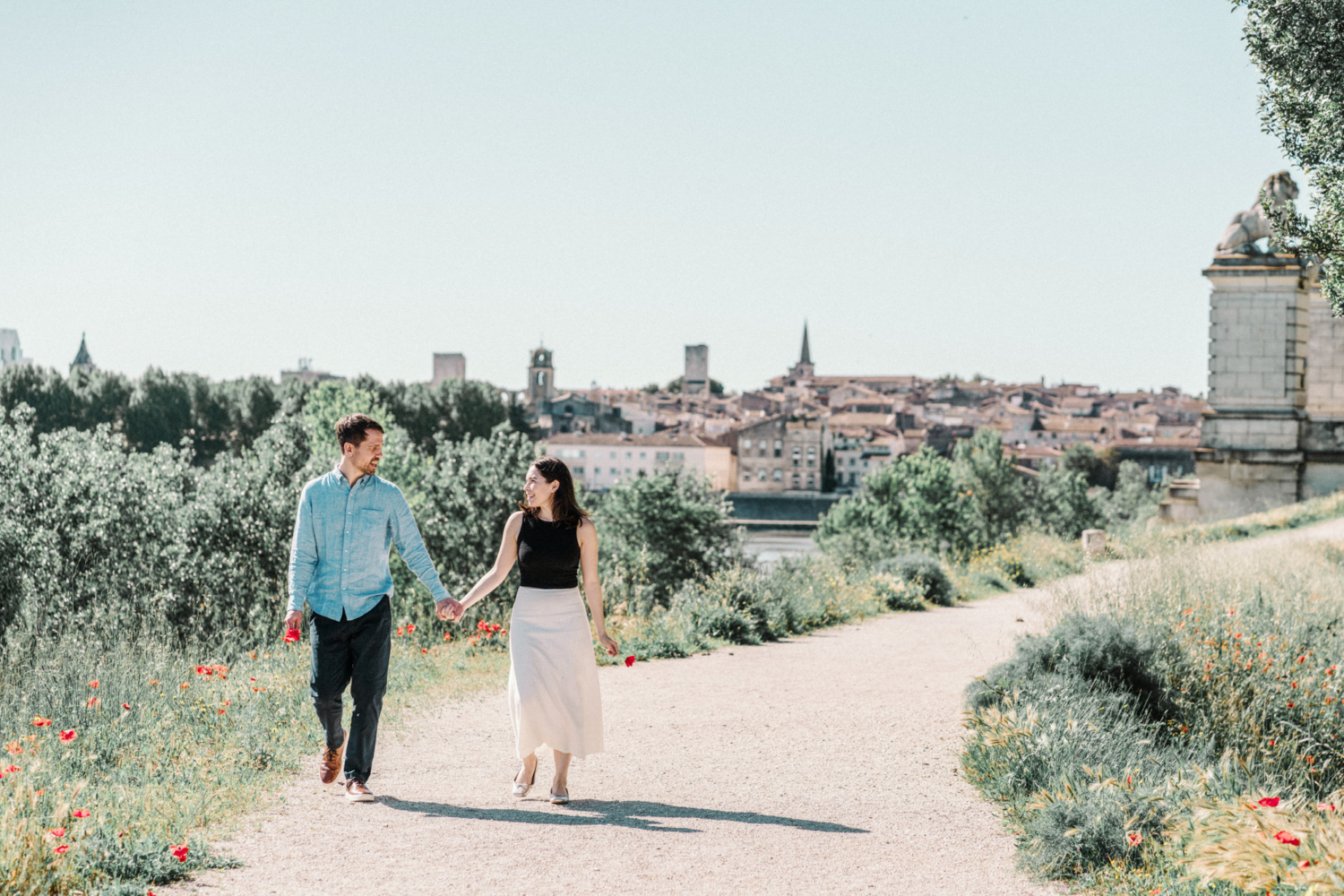 engaged couple walk hand in hand on trail in arles
