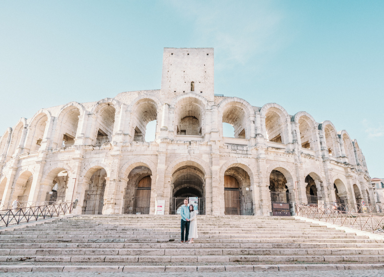 couple pose smiling on steps of roman amphitheatre in arles
