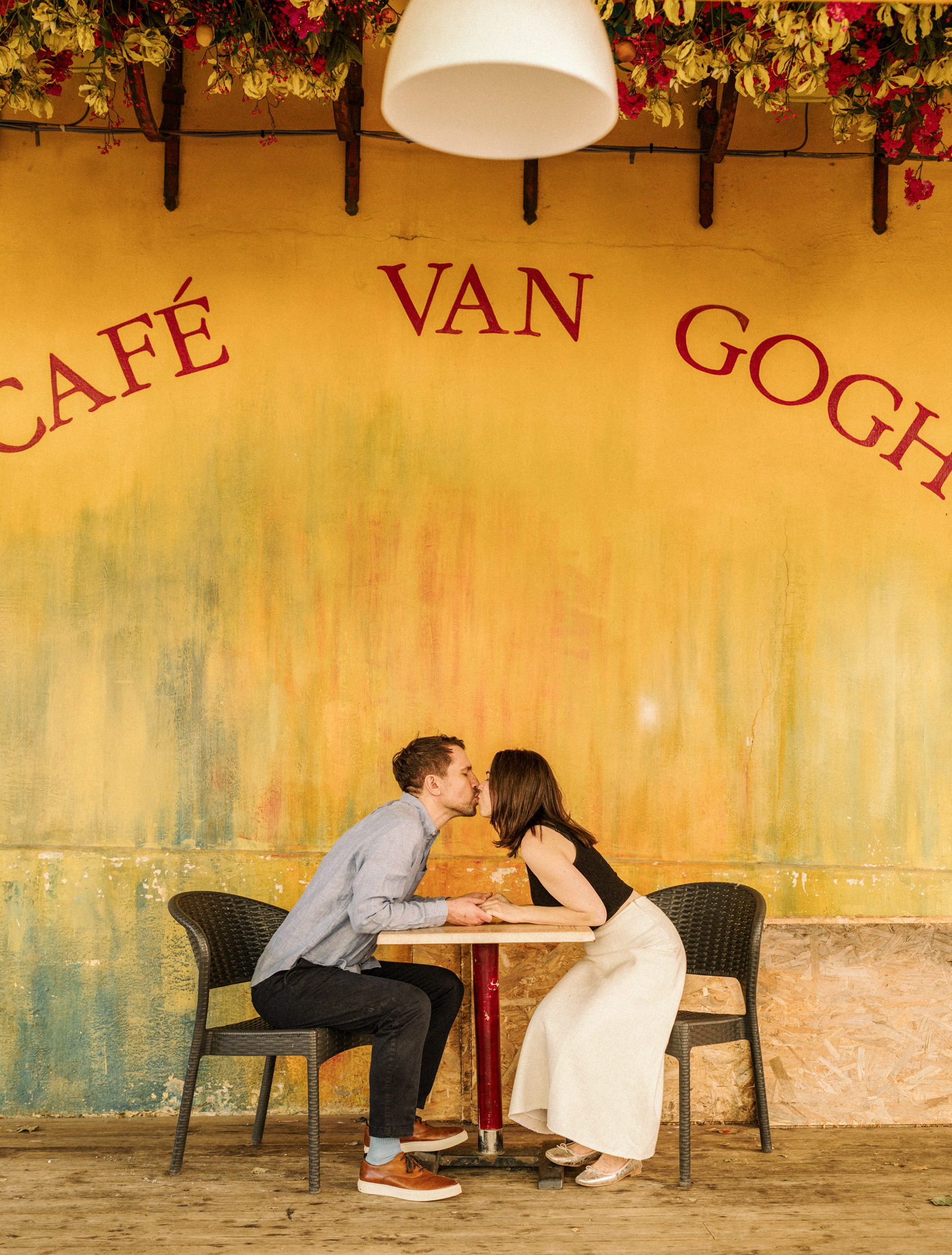 couple kiss in front of cafe van gogh arles during Engagement Photos In Provence