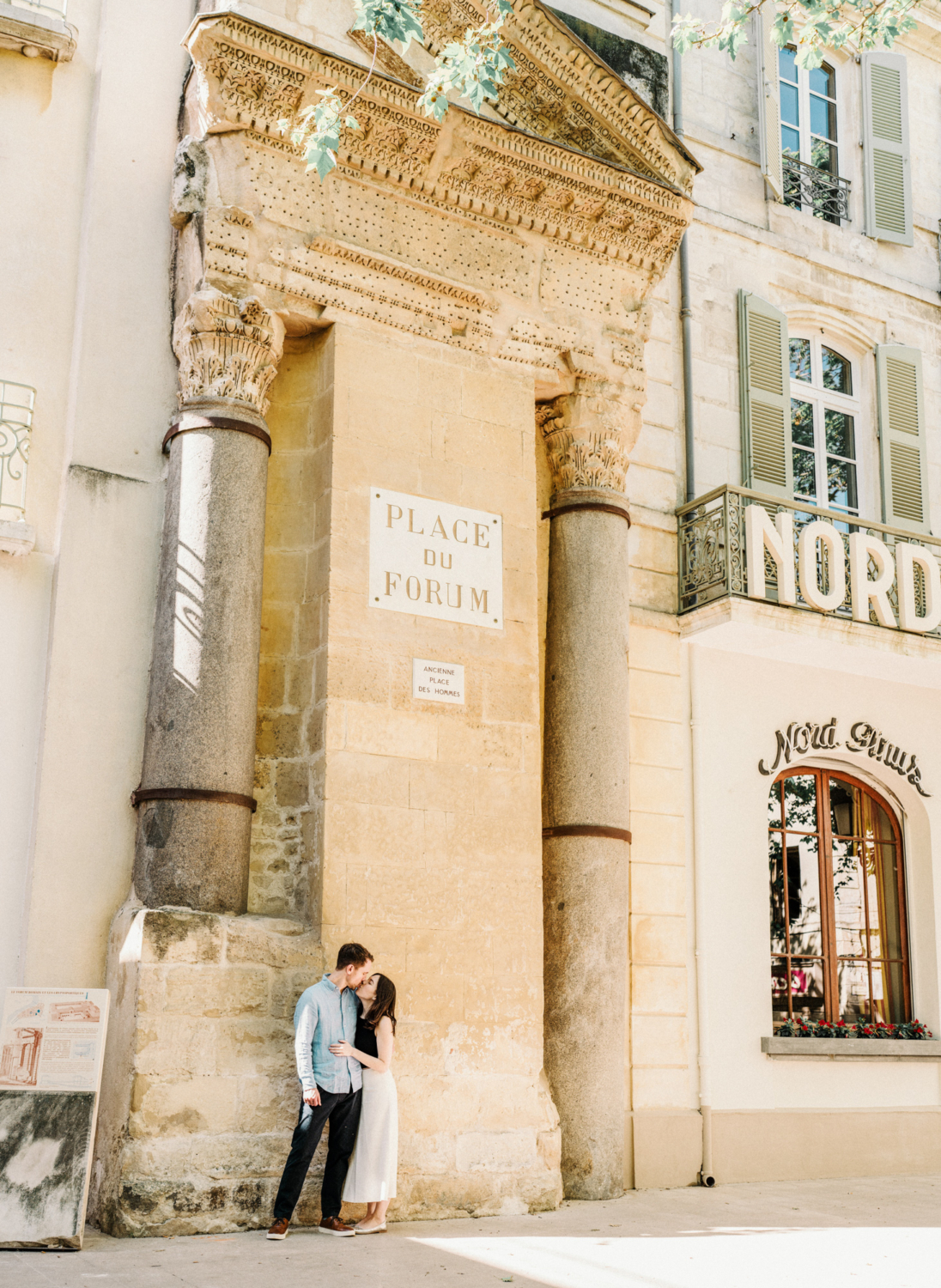 couple kiss in front of ancient roman column in arles