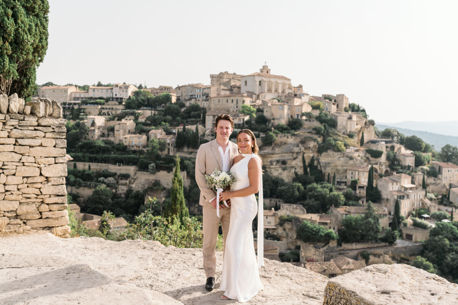 bride and groom smile posing in gordes france