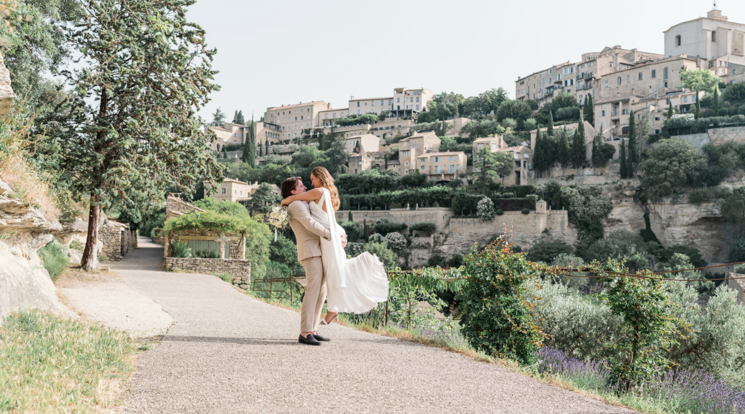 groom lifts bride in air in gordes france