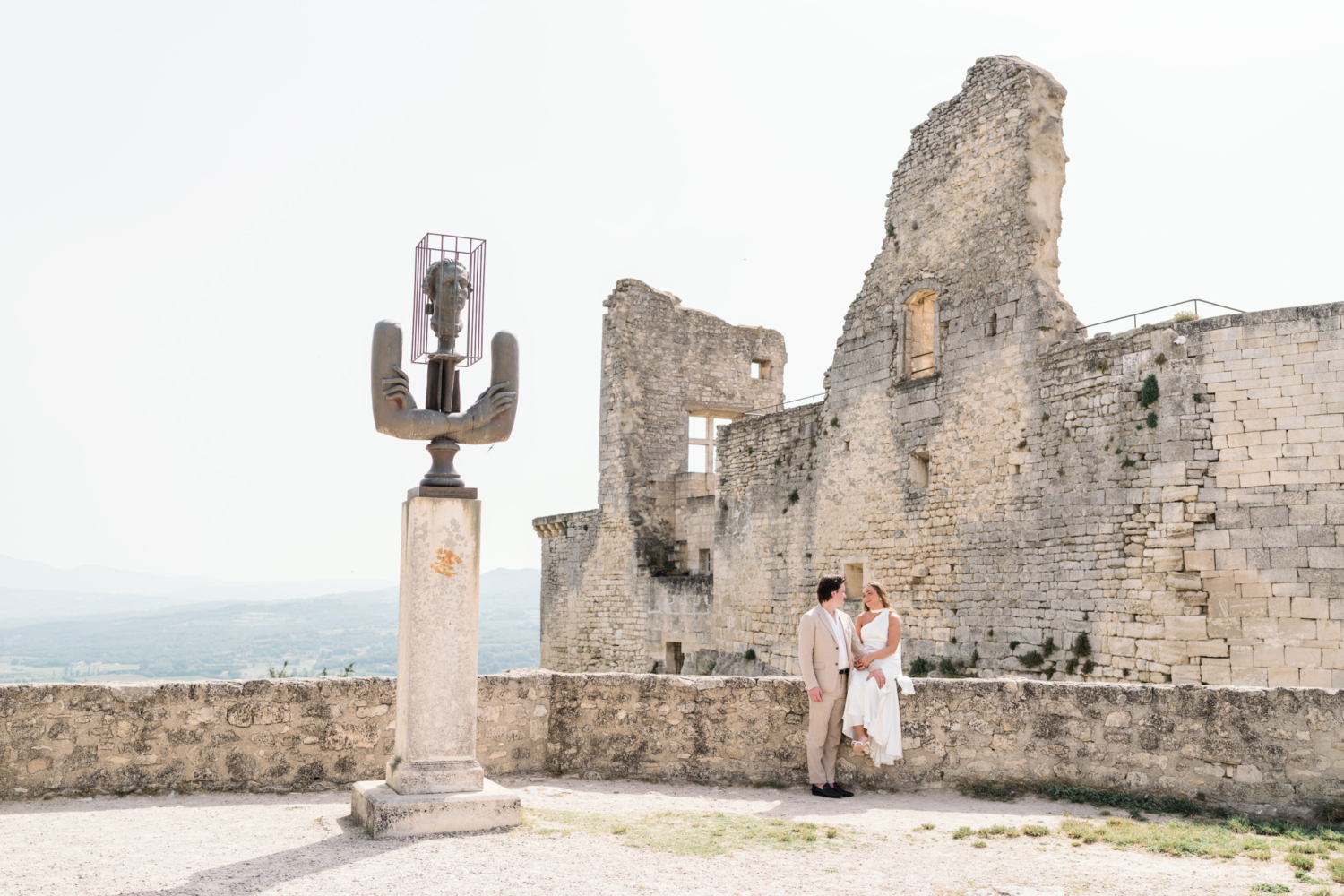 bride and groom pose at chateau in lacoste france