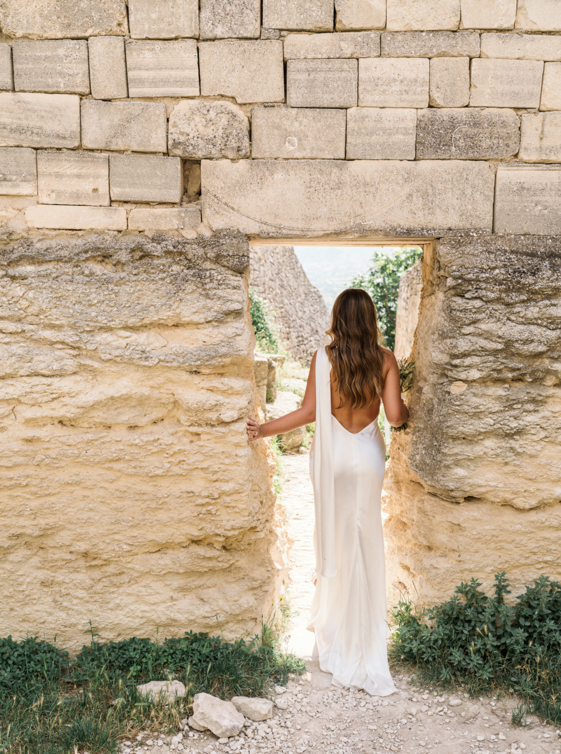 bride poses in doorway in lacoste france