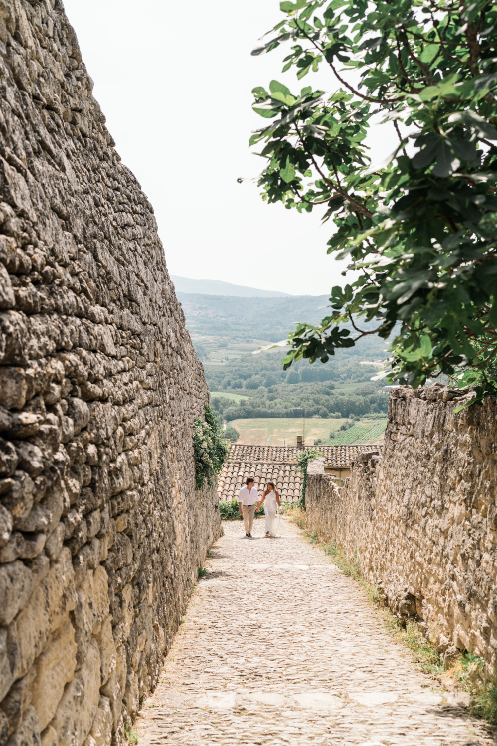 bride and groom walk hand in hand in lacoste france